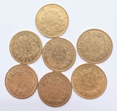 six types différents de pièces d'or sur une surface blanche
