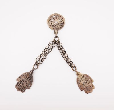 un gros plan sur une paire de boucles d'oreilles suspendues à une chaîne
