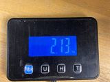 a digital clock on a wooden table with a cord