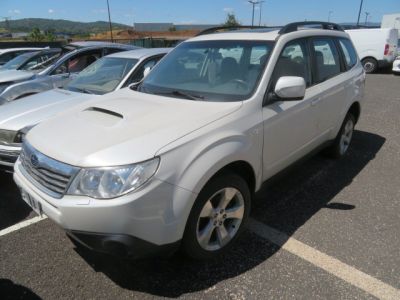 une Subaru blanche garée sur un parking avec d'autres voitures