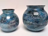 two blue vases sitting next to each other on a table