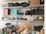 un ours en peluche posé sur une étagère dans une pièce encombrée