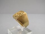 an image of a gold signet ring on a clear stand
