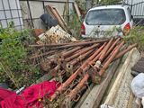 une voiture blanche garée à côté d'un tas de bois