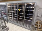 de nombreux réfrigérateurs vides dans un magasin, avec un chariot devant chacun d'eux
