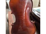a violin sitting on top of a wooden table next to a chair