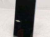 the back of a black cell phone sitting on top of a white table