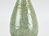 green glazed vase with floral design on a white background