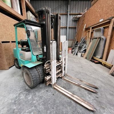 a forklift that is sitting in the middle of a warehouse