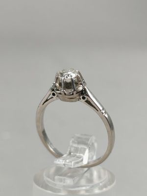 a close up of a diamond ring on a clear surface