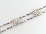 two silver chain bracelets on a white surface with a white background