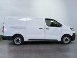 the white van is parked in a large room with a gray floor