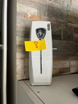 un téléphone sur lequel est collé un autocollant jaune, posé sur un comptoir
