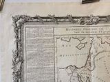 an old map on a table with a pen and paper