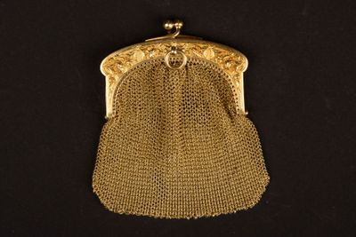 un sac à main en maille dorée à l'ancienne sur fond noir