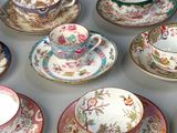 many cups and saucers sitting on a table