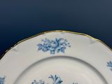 a blue and white plate with a gold rim