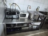une petite cuisine avec de nombreux appareils électroménagers posés sur le plan de travail