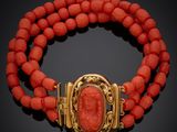 un bracelet en or et corail muni d'un fermoir orné d'une pierre rouge
