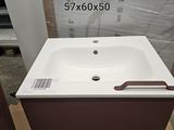 un lavabo blanc et un meuble marron dans une pièce