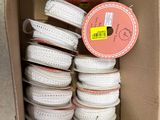 une boîte en carton remplie d'une multitude de bobines blanches et roses