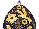 a close up of a black and gold pendant on a white background