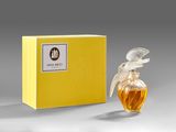a bottle of perfume sitting next to a yellow box