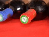 several bottles of wine are lined up on a red cloth