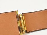 leather belt with a brass buckle on a white surface