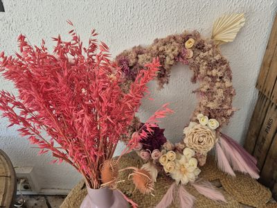 un vase rose avec quelques fleurs à l'intérieur, posé sur une table