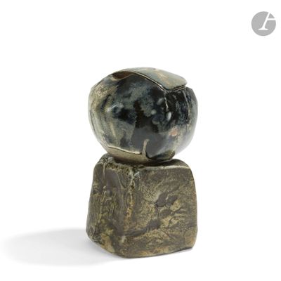 a stone ball sitting on top of a rock
