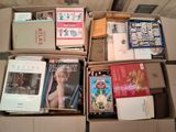 de nombreux livres qui se trouvent dans une boîte posée par terre
