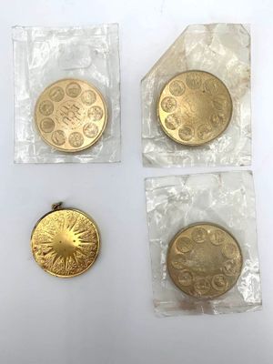 trois pièces d'or dans des sachets en plastique posées sur une surface blanche
