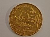 a gold coin with a picture of a man in bed on it