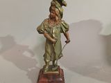 a bronze statue of a woman holding a cane