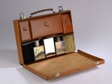 a brown briefcase with a lot of items inside of it
