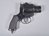 un vieux pistolet est posé sur une surface blanche, devant un fond blanc