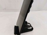 a small black tablet on a stand on a white surface