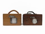 two wooden clocks sitting next to each other on a white surface