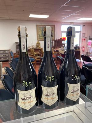 three bottles of wine sitting on a glass table in a room