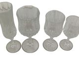four wine glasses sitting next to each other on a white surface