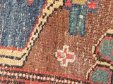 close up of a rug with a blue vase on top of it