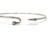 a close up of a silver bracelet with two small beads on it