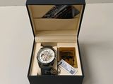 une montre dans une boîte et un livre sur la table