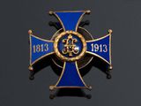 an image of a blue and gold cross with a crown on it