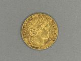 a close up of a gold coin on a gray surface