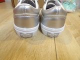 silver vans slip on sneakers on a wooden surface