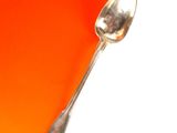une cuillère en argent sur un fond orange et blanc