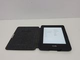 a kindle on the table next to a book