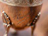 a silver cup with a handle on it on a table
